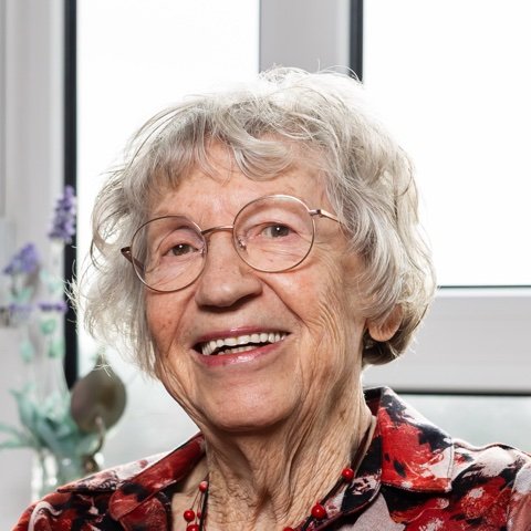 Portret van een lachende bewoonster met bril